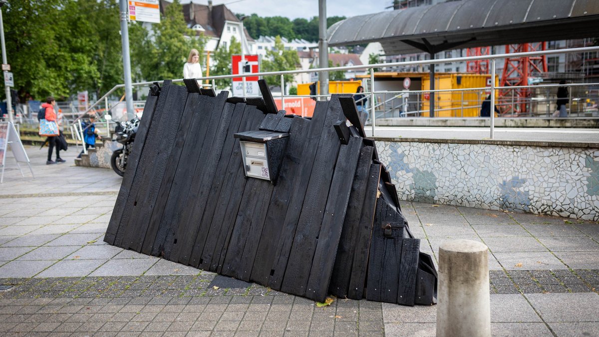 Vor dem Feuerbacher Bahnhof zwischen den S- und den U-Bahnsteigen steht eine Schutzhütte aus verkohlten Holzlatten. Vor dem Feuerbacher Bahnhof zwischen den S- und den U-Bahnsteigen steht eine Schutzhütte aus verkohlten Holzlatten.