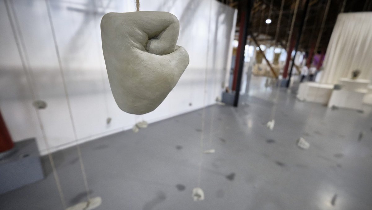 Handreichung für Besucher:innen? Die Gesten der 26 von der Decke herabhängenden tönernen Hände von Sabian Baumann sind frei interpretierbar. Handreichung für Besucher:innen? Die Gesten der 26 von der Decke herabhängenden tönernen Hände von Sabian Baumann sind frei interpretierbar.