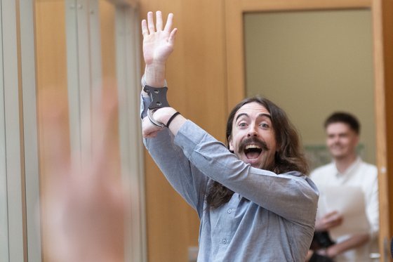 Der Angeklagte Daniel Tatlow-Devally begrüßt am ersten Verhandlungstag Unterstützer:innen im Publikum. Foto: Julian Rettig