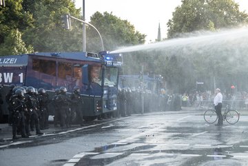 Immer wieder stellen sich Passanten vor die Einsatzfahrzeuge der Polizei. 