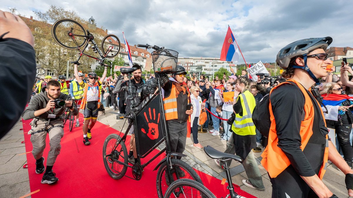 Einer kommt mit einem Tallbike. 