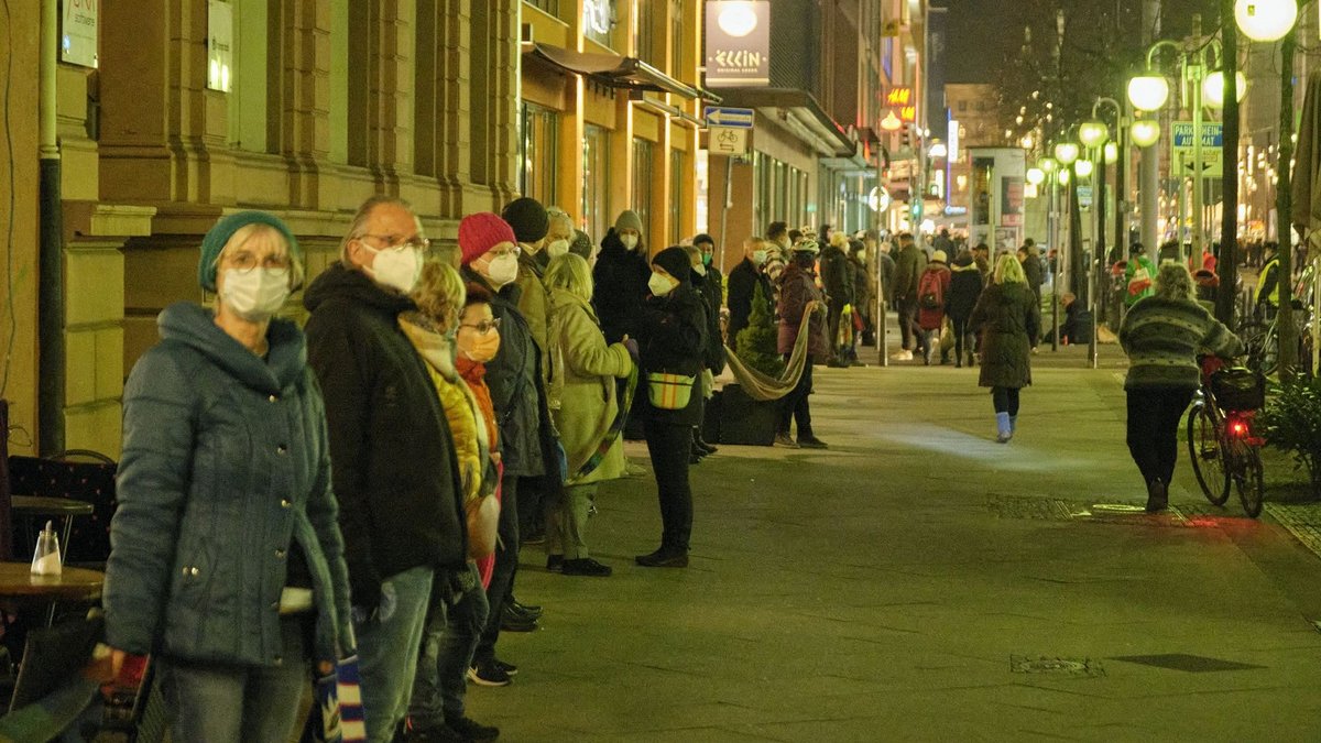 Hand in Schal in Hand: Die Menschenkette führt die Hauptstraße hinauf.