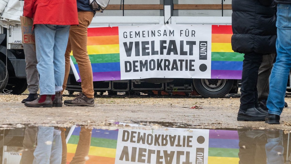 Symbolbild zum Auftakt des AfD-Landesparteitages: brauner Matsch vor einer bunten Botschaft für Vielfalt und Demokratie. 