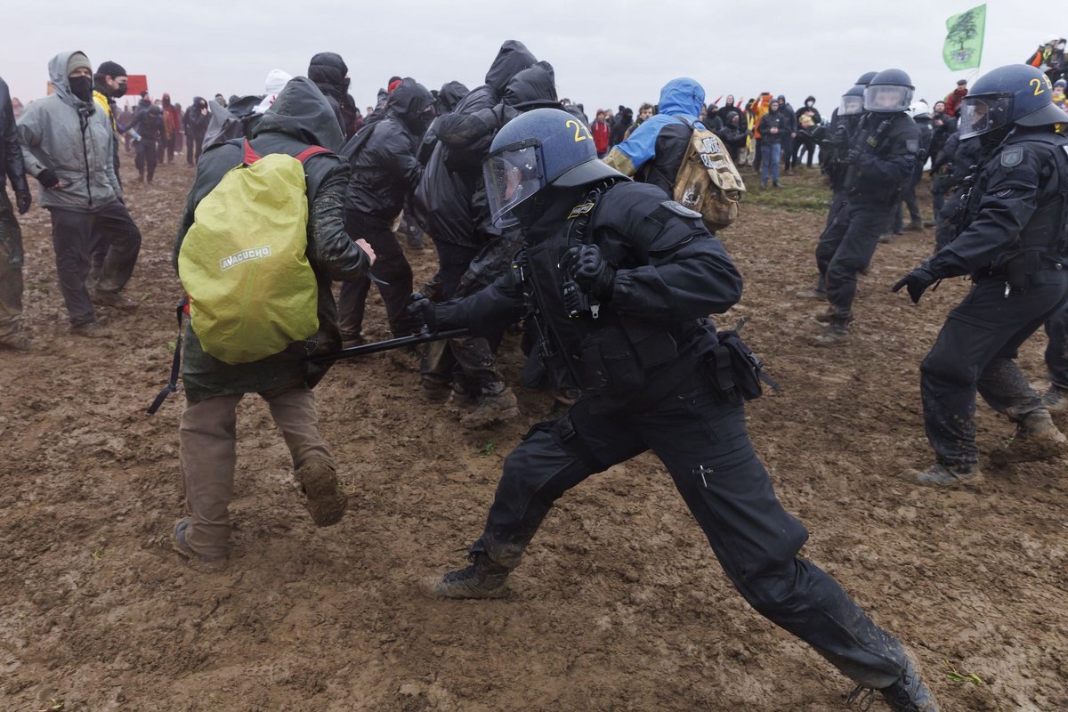 Ein Polizist trifft einen Demonstranten mit seinem Schlagstock.  Ein Polizist trifft einen Demonstranten mit seinem Schlagstock.
