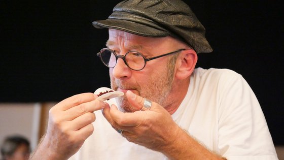 Selbst angebauter Reis auf Oblate: Berthold Biesinger vom Theater Lindenhof bei der Auftaktveranstaltung in Melchingen. Foto: Roland Frick