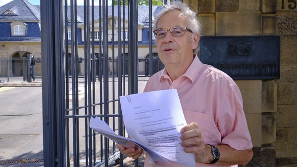 Dieter Reicherter mit seinen Akten-Notizen vor dem Staatsministerium.