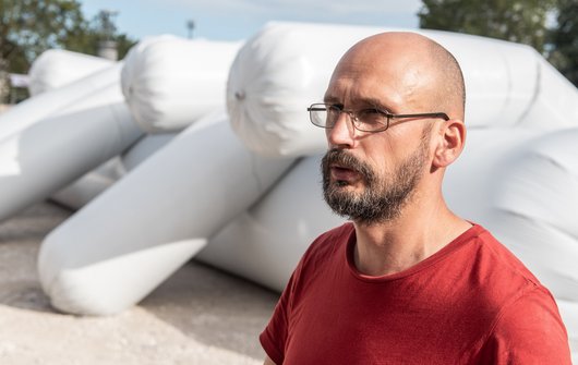 Künstler Kestas vor seinen aufgeblasenen Würsten.