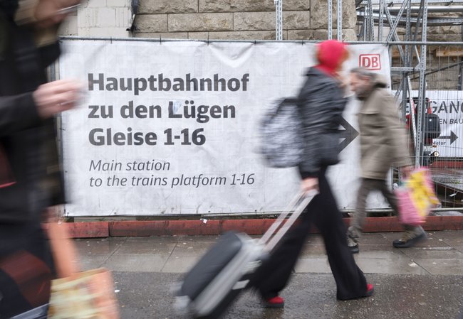 Ein wegweisendes Transparent am Bauzaun der Stuttgart-21-Baustelle, Unbekannte haben ein "Z" mit einem "L" überklebt, April 2024. 