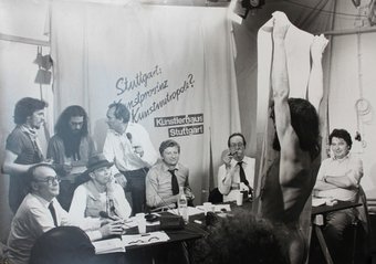 Mittig sitzen Beuys, Klett und Rommel, hinter ihnen steht Kurt Weidemann, links neben ihm zwei Hausbesetzer. Vorn ein nackter italienischer Künstler mit einer unangemeldeten Performance, die darin bestand, das Bild eines Gastarbeiters zu zeigen. Foto: El