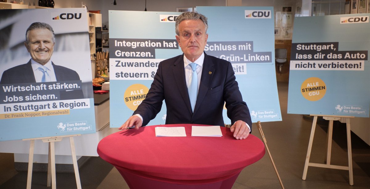 Stuttgarts OB Frank Nopper präsentiert Wahlplakate der örtlichen CDU.