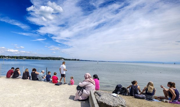 Touristen erholen sich am See vom Tourismus.
