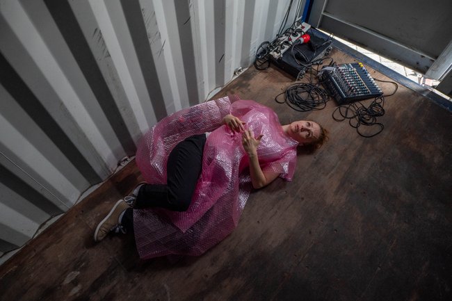 Laura Becker als serbische Arbeiterin, eingehüllt in Plastik.  Laura Becker als serbische Arbeiterin, eingehüllt in Plastik.