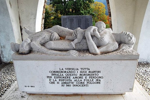 Das Mahnmal im Beinhaus von Sant'Anna di Stazzema. Im Hintergrund die Gedenktafel mit den Namen der Opfer. Foto: http://www.vittimeinnocenti.altervista.org