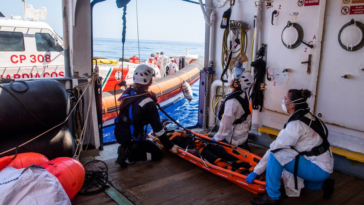 Medizinischer Notfall: Ein junger Mann wird zur weiteren Behandlung an die italienische Küstenwache übergeben. 