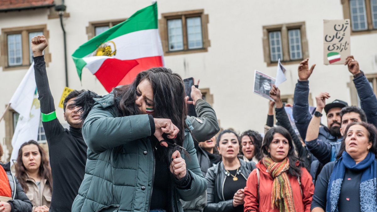 Nach dem gewaltsamen Tod von Jina Mahsa Amini im September 2022 schnitten viele Iranerinnen als Zeichen der Solidarität ihre Haare ab, auch auf dem Stuttgarter Schillerplatz. Rechts der Slogan "Frau, Leben, Freiheit". Foto: Jens Volle