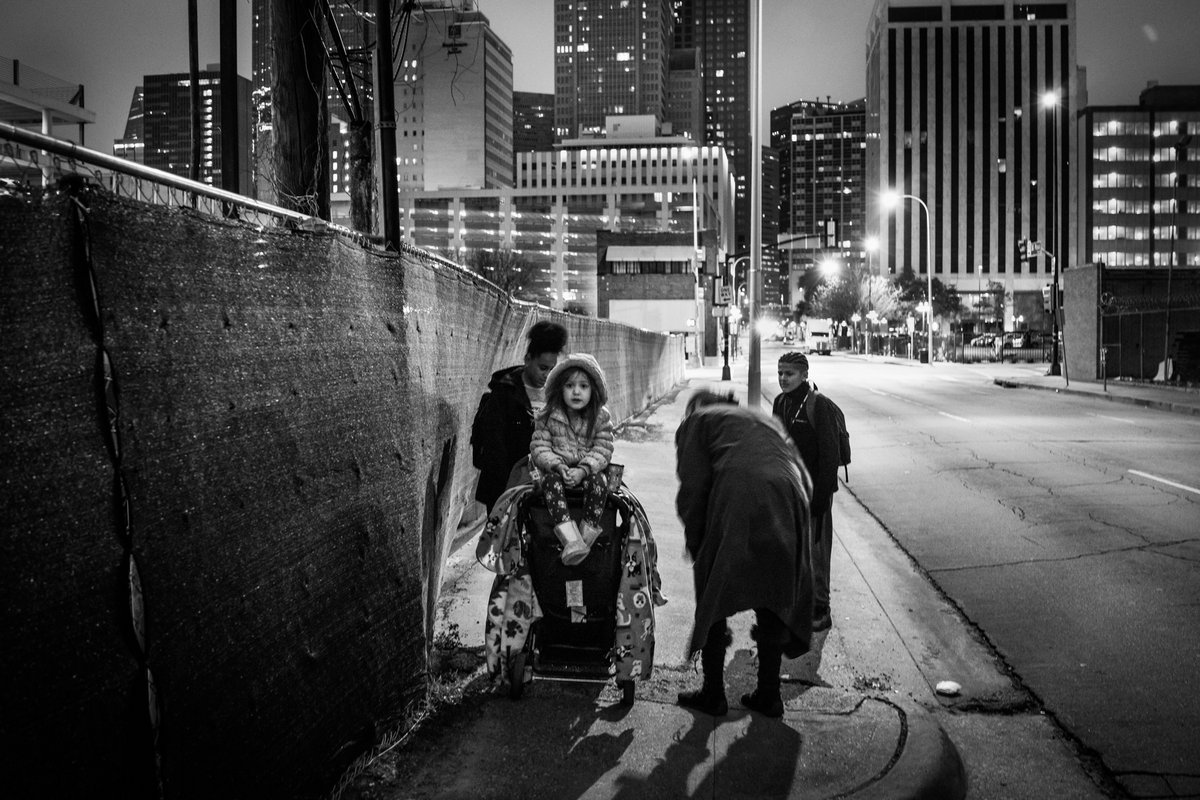 Eine obdachlose Mutter verlässt vor Sonnenaufgang ein Notquartier, um ihre beiden Teenager zur Bushaltestelle zu bringen, damit sie eine 45 Minuten entfernte Schule erreichen können. Dallas, Texas, Januar 2019.