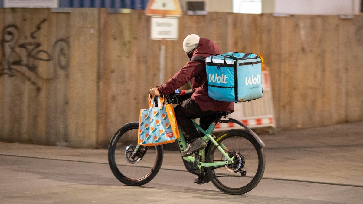 Harte Arbeit: auf dem Rücken warme Speisen anderer, am Lenkrad den eigenen Einkauf in der Tasche. Foto: Julian Rettig