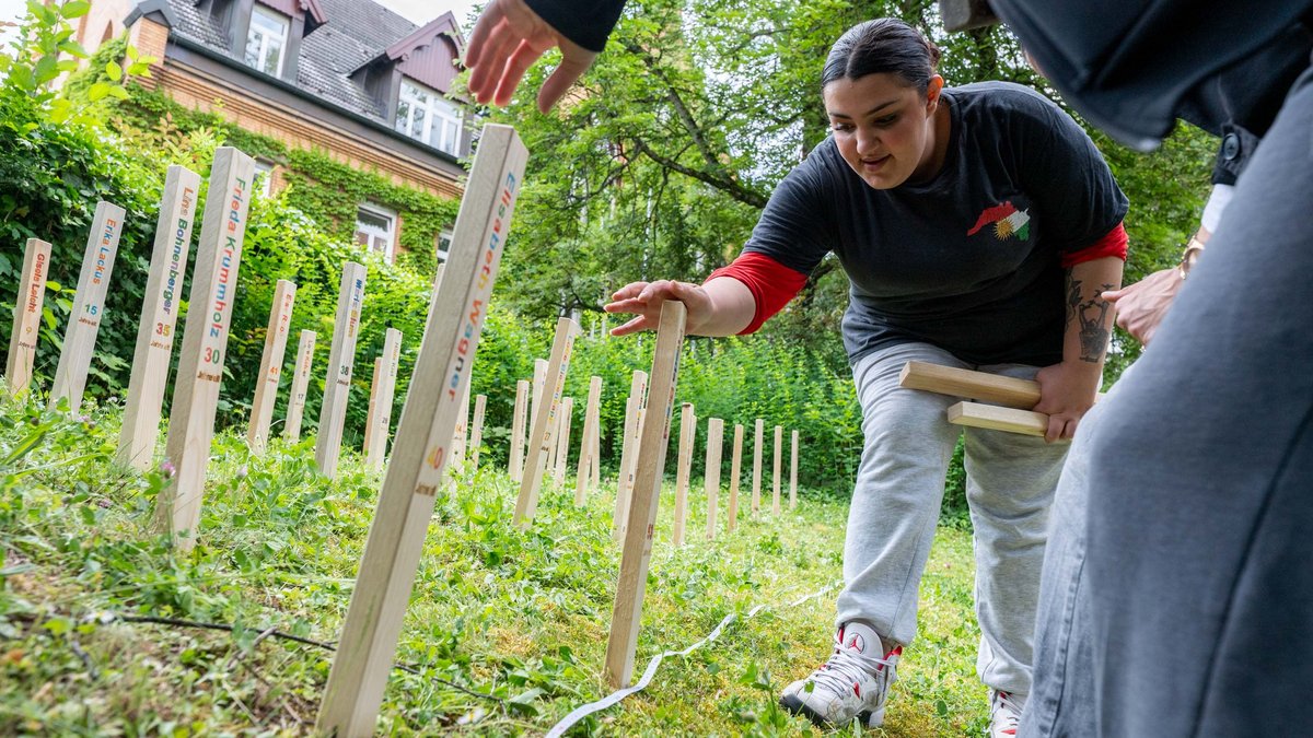Arina und ihre Mitschüler:innen setzen Holzstelen zur Erinnerung an die ermordeten Korker Frauen.