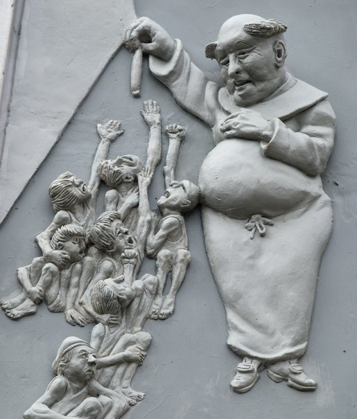 Mit Würstchen lockt ein beleibter Gottesmann die hungernden Kinder.