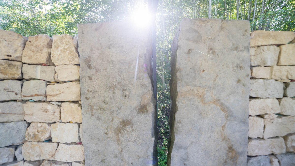 Der Riss in der Mauer der Gedenkstätte symbolisiert das Verbrechen: eine Narbe, die nicht heilt.