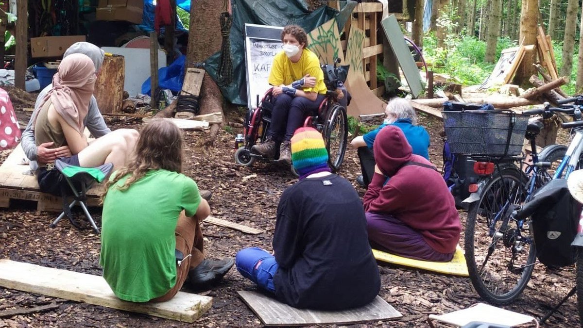 Juni 2021: Die Kletteraktivistin Cécile Lecomte (gelbes T-Shirt) ist zu Besuch im Altdorfer Wald und liest aus ihrem Buch "Kommen sie da runter!" vor.