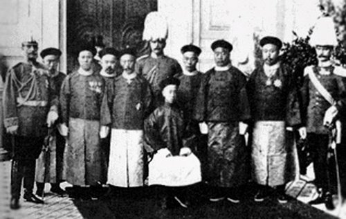 Demütigung: Der "Sühneprinz" Chun (sitzend) in Potsdam. Foto: Unbekannt. <p><a href="https://de.wikipedia.org/w/index.php?curid=615206">Link</a></p> Demütigung: Der "Sühneprinz" Chun (sitzend) in Potsdam. Foto: Unbekannt. <p><a href="https://de.wikipedia.org/w/index.php?curid=615206">Link</a></p>