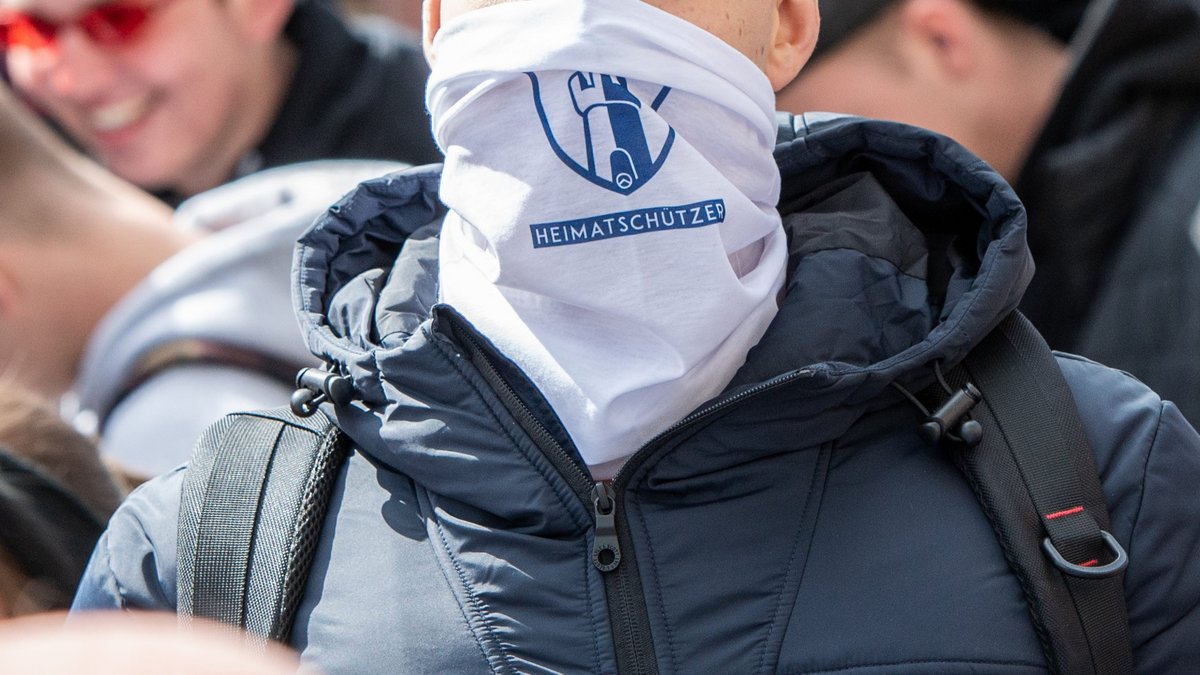 Ein Identitärer – das kreisrunde Logo seiner Bewegung versteckt sich im Turmeingang. Foto: Jens Volle