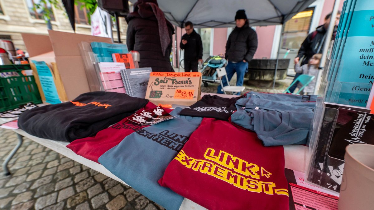 Eine Mahnwache vor dem Landgericht bietet Soli-T-Shirts mit der Aufschrift "Link-Extremist_in" an. 