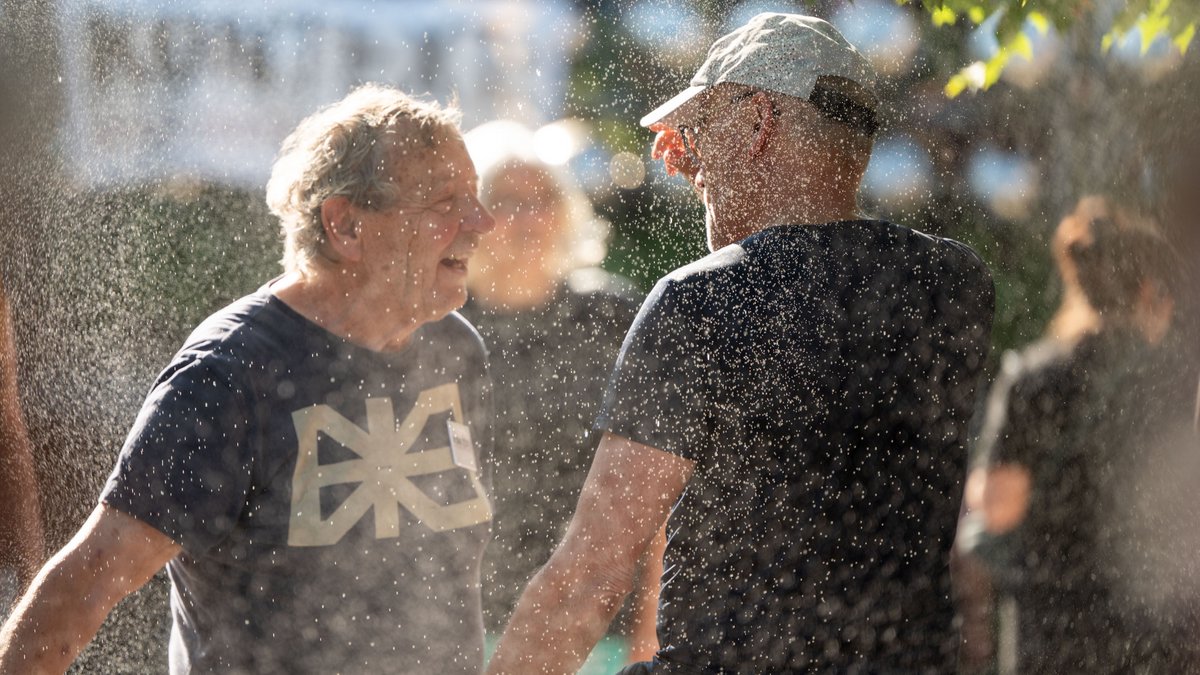 Wiederum andere ließen sich vom künstlichen Sprühregen berieseln. Hier: Kontext-Wetterer Peter Grohmann und Fotograf Martin Storz. 