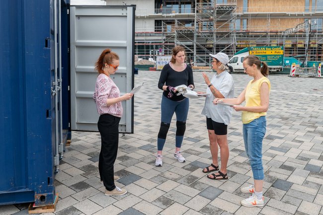 Besprechung vor dem Container. Von links: Schauspielerin Laura Becker, Tänzerin Kira Senkpiel, Pavla Jenková (wissenschaftliche Mitarbeit) und Regisseurin Adelheid Schulz.  Besprechung vor dem Container. Von links: Schauspielerin Laura Becker, Tänzerin Kira Senkpiel, Pavla Jenková (wissenschaftliche Mitarbeit) und Regisseurin Adelheid Schulz.
