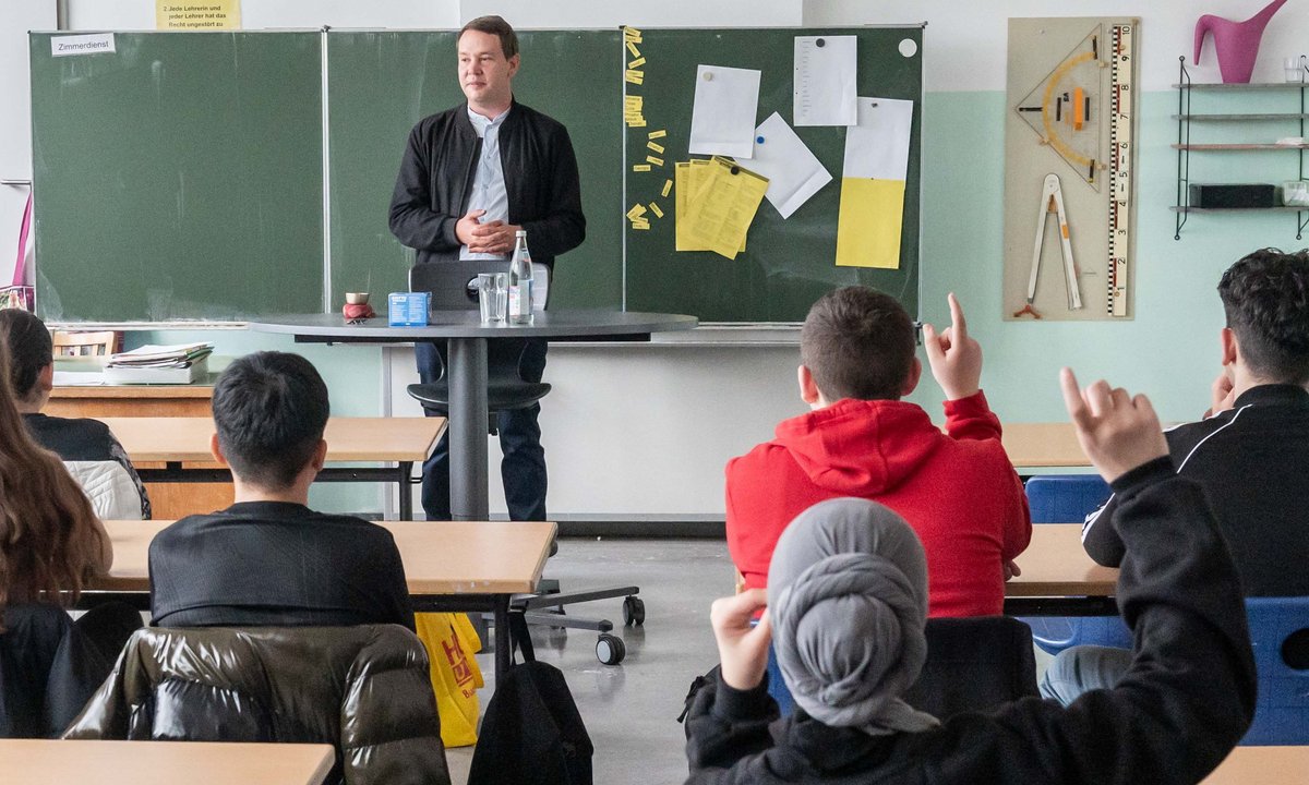 20 Augenpaare sind auf ihn gerichtet: Oliver Hildenbrand zu Besuch bei der 8b. Die Schüler:innen fragen ihn querbeet durch alle Politikthemen. 