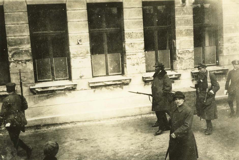 Gustav Landauer auf dem Weg zum Gefängnis Stadelheim, wo er am 2. Mai ermordet wurde (Hinter Landauer geht ein Wachmann, sodass er ein Gewehr mit Bajonett zu tragen scheint), Internationales Institut für Sozialgeschichte, Amsterdam 